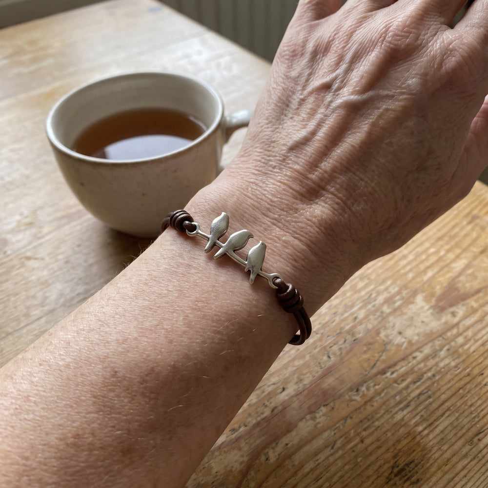 The bracelet worn on the wrist beside a cup of tea
